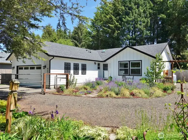 Front of this remodeled home w/ gorgeous landscaping providing your own oasis at the Beach.