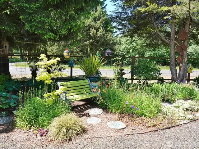 Relax on this bench in the front yard surrounded by the beautiful landscaping.