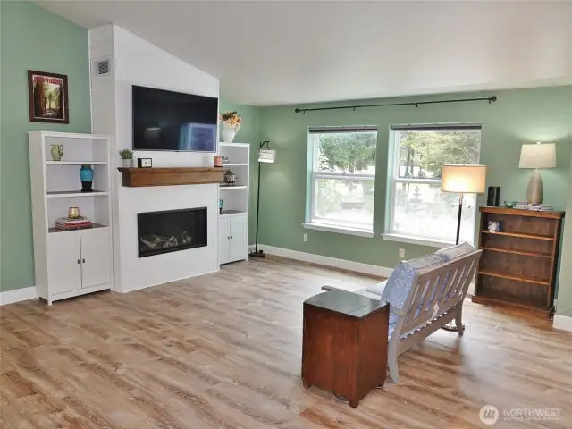 Living Room w/ propane fireplace and views out onto the beautifully landscaped front yard.