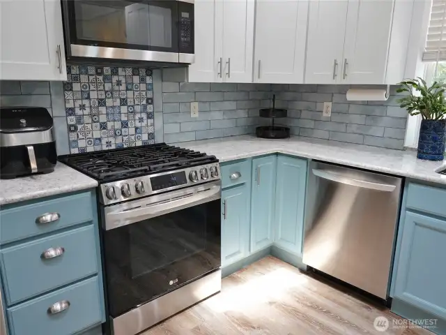 Kitchen w/ propane range and a stylish tile backsplash.
