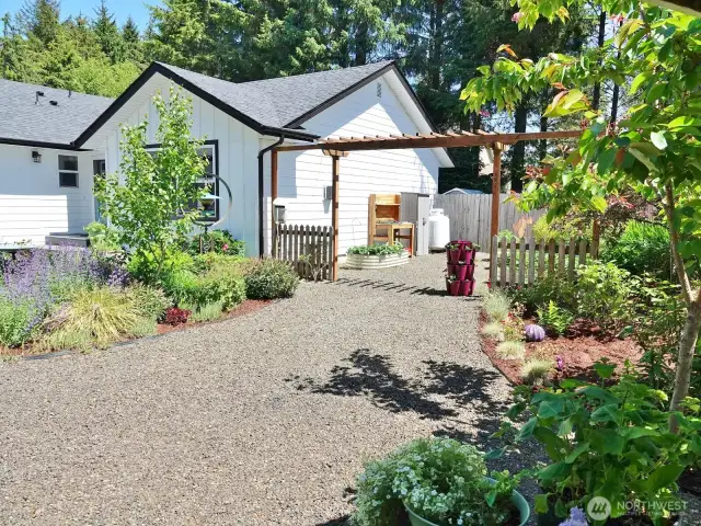 Front yard w/ a large gravel walkway between the front areas and the side yard into the backyard.