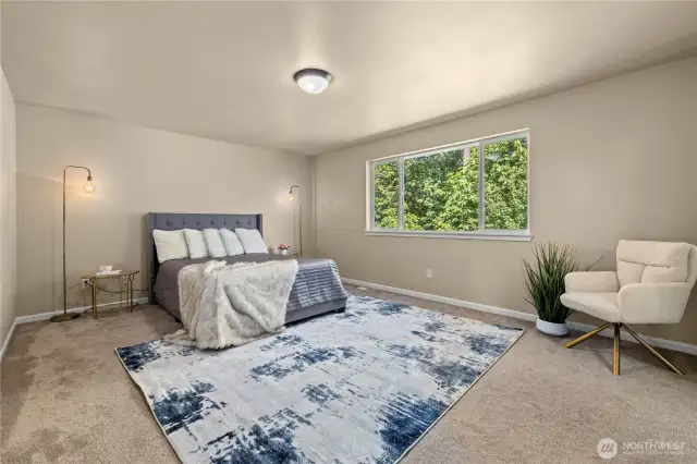 Spacious upstairs primary suite with greenbelt views and private bath – Puyallup, WA    This elegant primary bedroom suite on the second floor offers a peaceful escape with tranquil greenbelt views just beyond the expansive window. Located in the desirable LaGrande Station neighborhood of Puyallup, this oversized retreat features plush carpeting, neutral tones, and ample space for a sitting area or reading nook. The private en-suite bathroom ensures comfort and privacy, making this a true owner's sanctuary in a serene, tree-lined setting just minutes from shopping, schools, and commuter options.