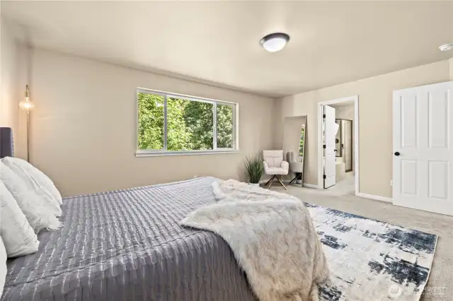 Upstairs primary suite with ensuite bathroom and peaceful greenbelt view – Puyallup, WA    Wake up to nature in this upstairs primary bedroom retreat, featuring lush greenbelt views and direct access to a private spa-style ensuite bathroom. Located in the highly sought-after LaGrande Station neighborhood in Puyallup, this serene space offers a cozy reading nook, soft carpeting, and abundant natural light. A perfect sanctuary after a long day, all while being minutes from the Sounder Train, South Hill Mall, and top-rated schools.