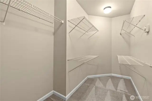Spacious walk-in closet in the primary suite – Puyallup, WA home for sale    Stay organized in this generously sized walk-in closet, conveniently connected to the private ensuite bathroom in the primary bedroom. With multiple shelves and hanging racks, there's ample storage for clothing, shoes, and accessories. A must-have feature for anyone seeking comfort and functionality in their next Puyallup home.