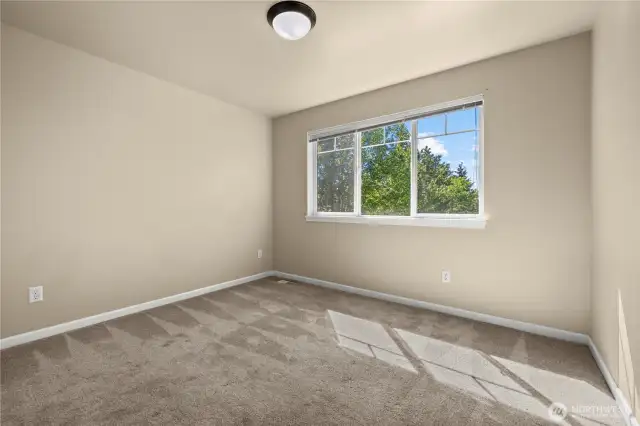 This upstairs bedroom in Puyallup’s LaGrande Station community offers a peaceful retreat with a front-facing window that overlooks Chateau Dr. Located on the top floor, the room is filled with natural light and features neutral carpet, soft paint tones, and a functional layout ideal for a guest room, home office, or personal sanctuary. Enjoy views of the tree-lined street and neighborhood charm from this bright and versatile space in one of Puyallup, WA’s most sought-after locations.