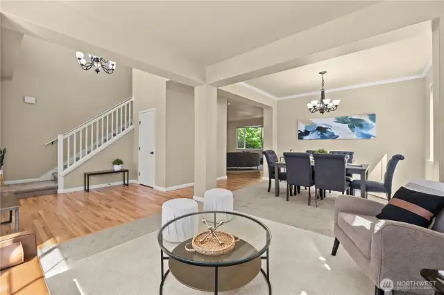 This thoughtfully designed open-concept main floor in Puyallup’s LaGrande Station community offers seamless flow between the formal living room, dining area, and entryway. Rich hardwood floors complement soft carpeted zones, while oversized windows bring in natural light and highlight the welcoming layout. Crown molding, modern lighting, and architectural columns add elegance and structure to the space. The open staircase and multiple seating areas make it easy to entertain or relax in comfort. Located near top schools, transit, and shopping, this layout offers both function and style in one of Puyallup, WA’s most desirable neighborhoods.