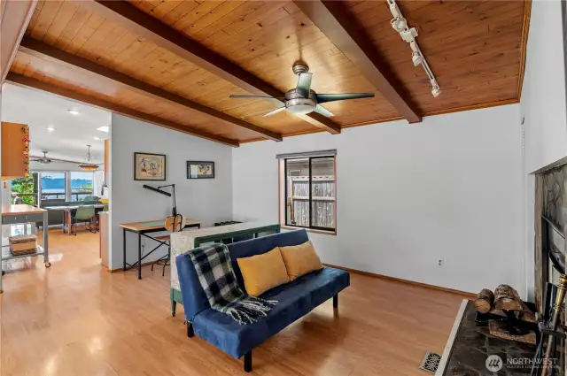 Check out those gorgeous beams and wood ceiling. Another ceiling fan keeps the heat circulating from the fireplace, and we love more lights. Another window to keep the cross-breezes going.
