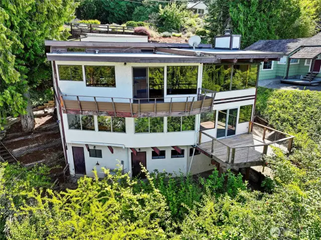 Back of home with lots of windows and 2 view decks.