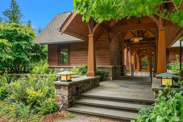 Main entry with custom crafted wooden arches lining the covered breezeway