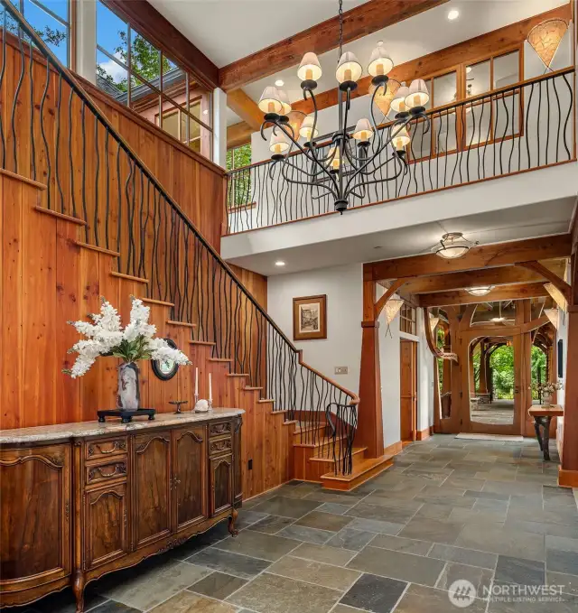 The grand entry hall continues the arches theme and showcases the artisan created iron railing on the stairway