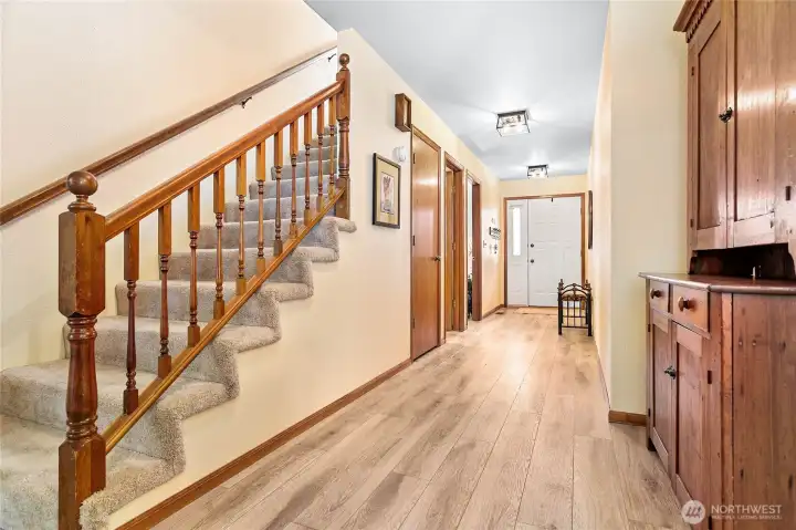 Another view of the front door, stair way leads to upstairs loft area. The whole main floor has been updated with  LVP wood flooring.