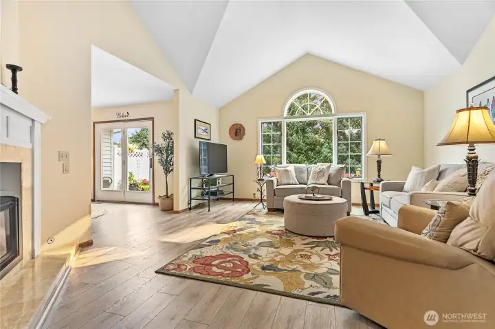 Living room with high vaulted ceilings, gas fireplace & big windows