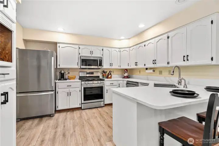 This kitchen features quartz counters, updated cabinetry, appliances & more!