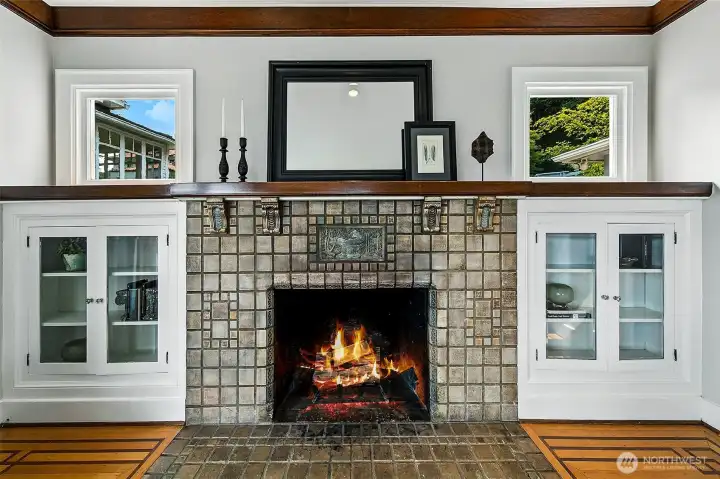 The original tile fireplace gracefully framed with glass bookshelves.