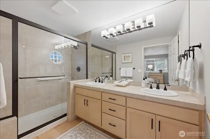 Large shower with bench and double sinks; private water closet