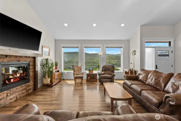 featuring large windows with valley views, a stone electric fireplace,
