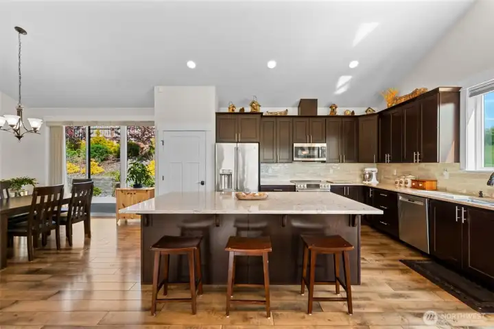 Designed for both everyday living and entertaining, this open-concept kitchen showcases rich cabinetry, quartz surfaces,