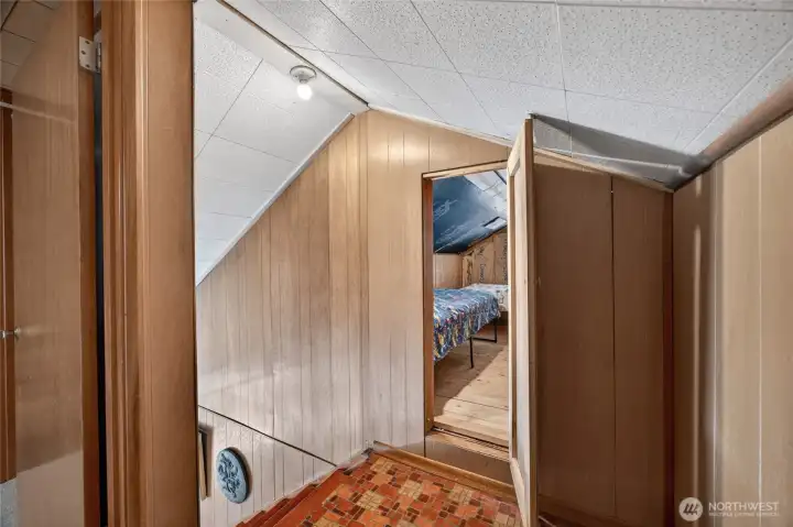 Panel door at the top of the stairs opens to attic bedroom.