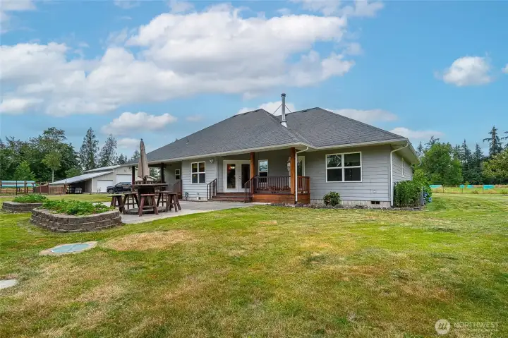 Rear right side of home with 2 raised strawberry beds, covered deck for grilling, 3 seperate exterior entrances to outdoor deck & patio. Great for outdoor living. Rear right side of home with 2 raised strawberry beds, covered deck for grilling, 3 seperate exterior entrances to outdoor deck & patio. Great for outdoor living.