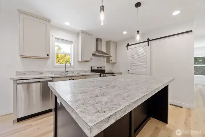 Easy to use kitchen with a barn door leading into the utility/laundry room.