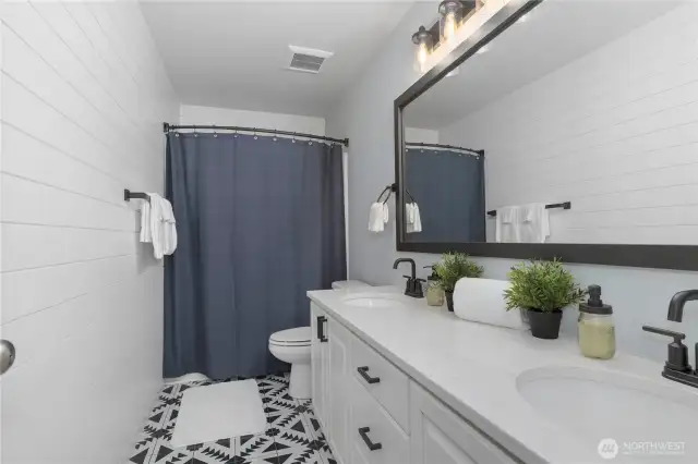 Updated hall bath has shiplap wall to take it from builder basic to fabulous