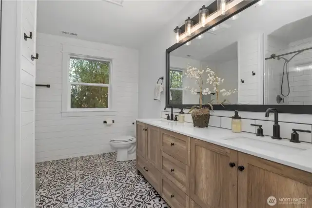 Primary bathroom has been updated with new tile floors, updated vanity and mirror as well as separated tub and shower.