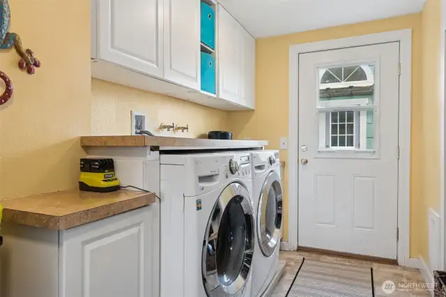 Large laundry/mud room with door to rear yard.