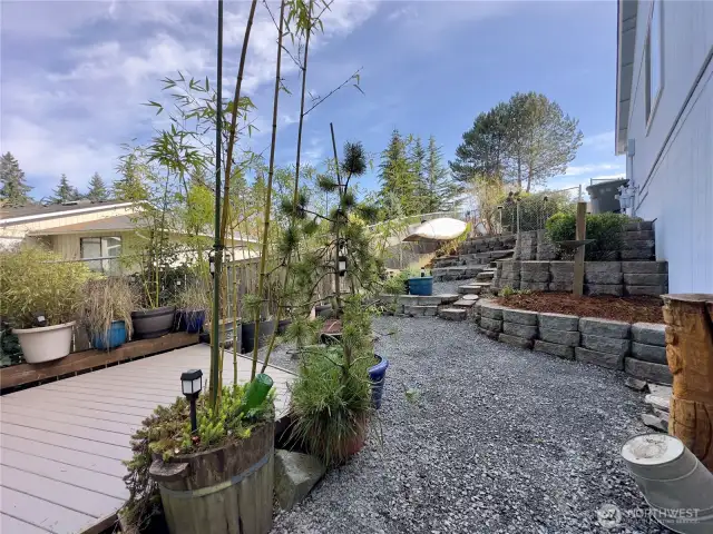 Side yard oasis with deck, terraced path, & plants