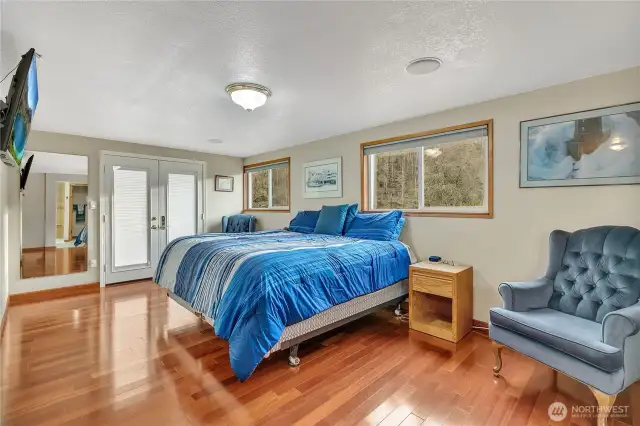 Primary bedroom with french doors to the back deck.