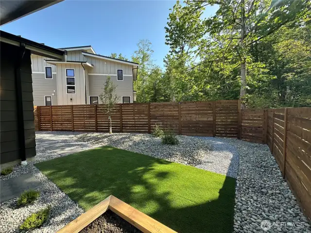 Fully fenced backyard, two large raised bed garden planters and covered patio area that overlooks the beautiful greenspace