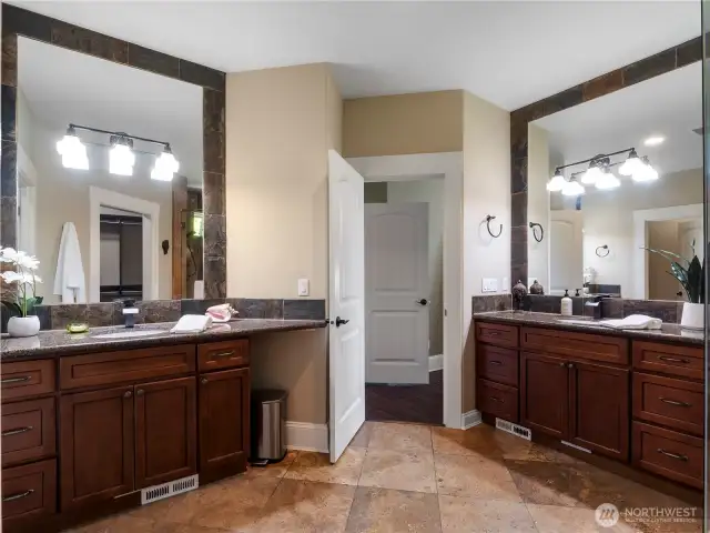 Create your own spa experience in this primary ensuite with separate vanities, granite countertops, travertine tile floors...