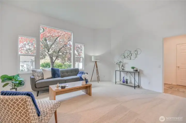 Living room with high ceilings, vinyl windows, easy access to front door and garage.