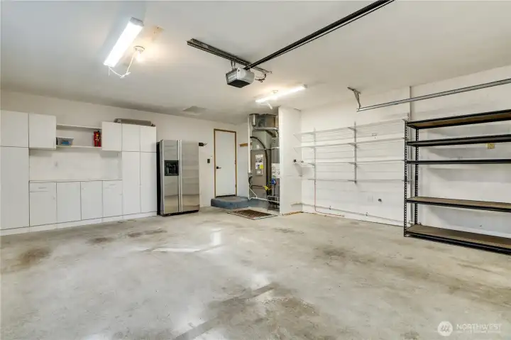 Very roomy two car garage with shelving and an extra fridge!
