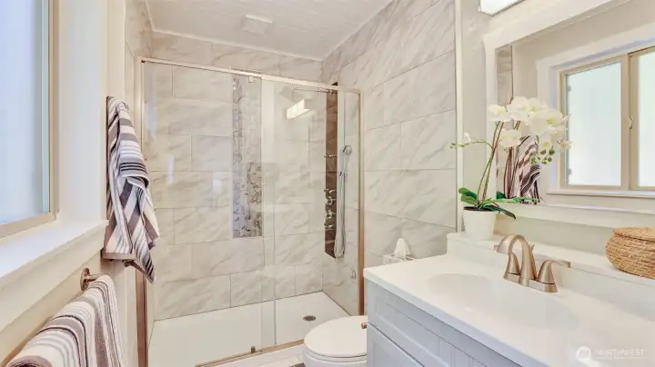 The primary bath en suite offers a beautiful tile walk in shower.
