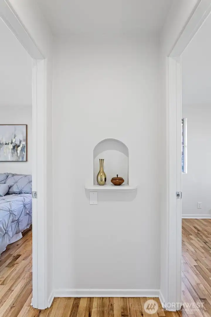 An arched display niche introduces architectural character, balanced by generous built-in linen storage across the hall.