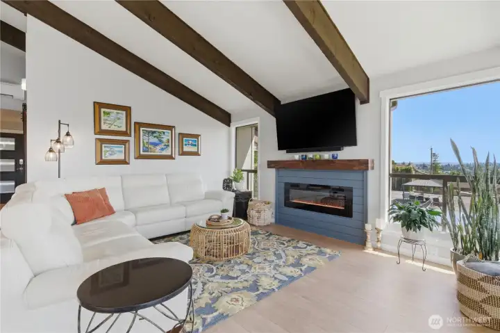 Living room fireplace is beautifully framed by windows—bringing in natural light and perfectly showcasing the surrounding views.