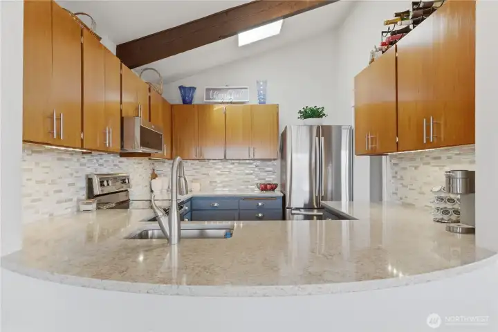 Curved countertop offers a welcoming spot for casual dining—perfectly sized to accommodate two barstools for easy, everyday meals or morning coffee.