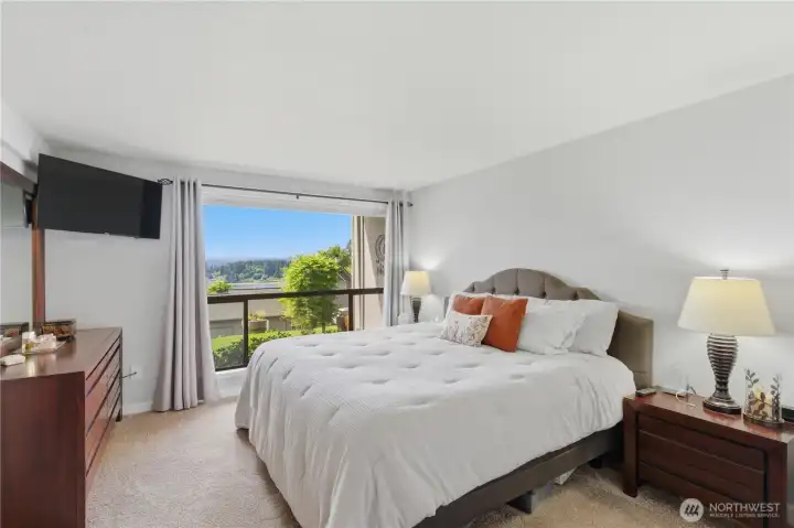 Primary bedroom on the lower level features a large picture window—bringing in natural light and creating a peaceful, retreat-like setting.