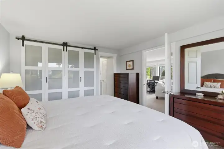 Glass inserts on the closet doors enhance the ambiance of the primary bedroom—adding light, depth, and a touch of modern elegance.
