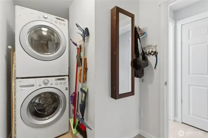 Full-size stackable washer and dryer conveniently tucked out of sight—functional, space-saving, and neatly hidden to keep the area looking clean and uncluttered.