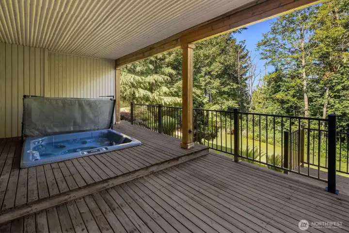 Covered lower back deck for hot tub is just through the french doors in the lower level living room.