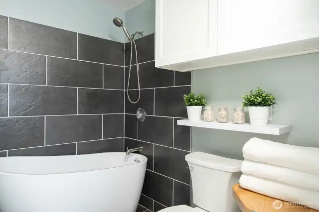 A deep soaking tub and sleek shower frame the space, blending comfort with style.