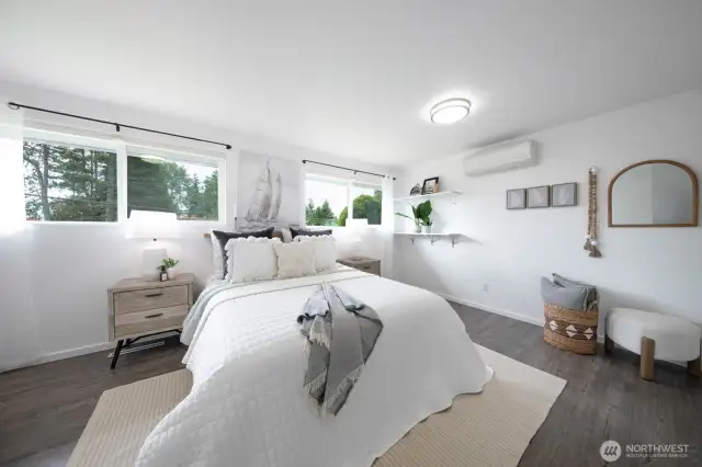 The primary bedroom offers space and serenity, with tree-lined views through the windows and a sleek, modern design.