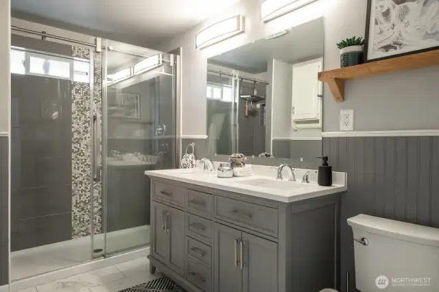 Enjoy a dual-sink vanity and timeless wood detailing that adds warmth and character to the walls.
