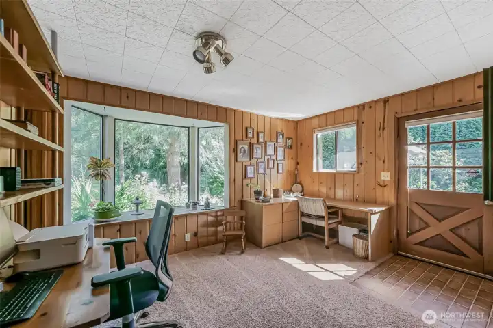 Office area with bay-window looking out towards serene landscape.