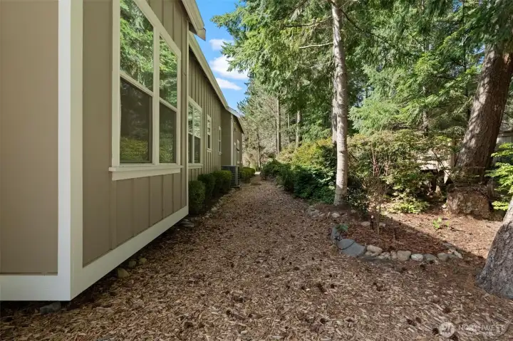 The side yard has a lush green belt for privacy