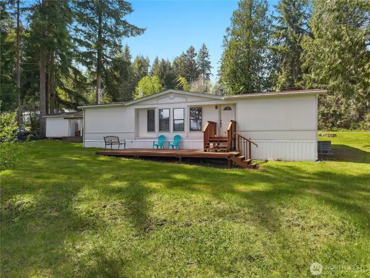 Welcome to your single-level home with front deck, generous lawn space, and peaceful natural surroundings.