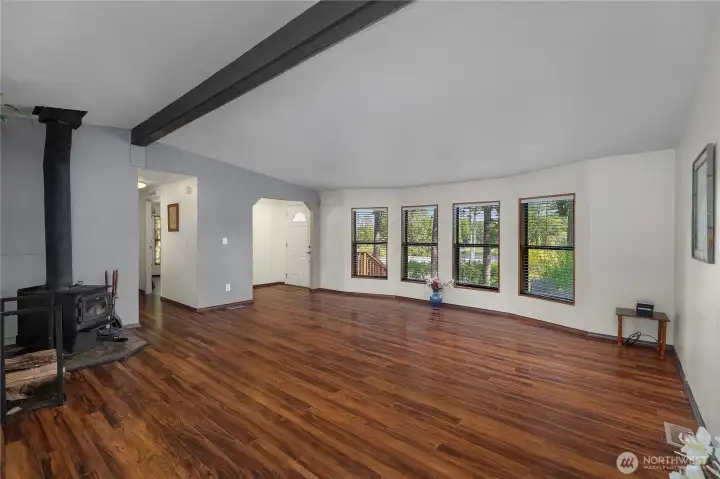 Inviting living room with woodstove, large windows, and an easy connection to the entry.