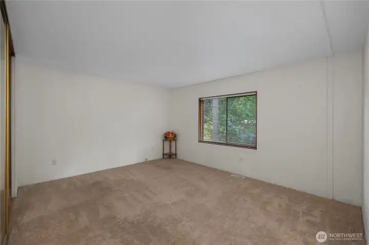 Primary BR - Spacious bedroom includes neutral finishes, large closet doors, and a quiet setting.
