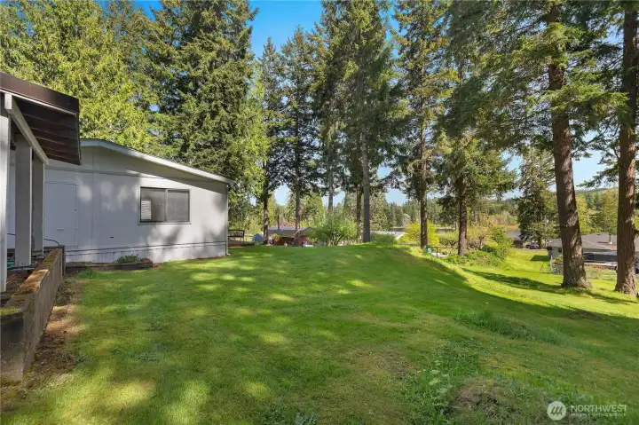 Relax in the shaded backyard with mature trees and a peek toward the lake beyond.